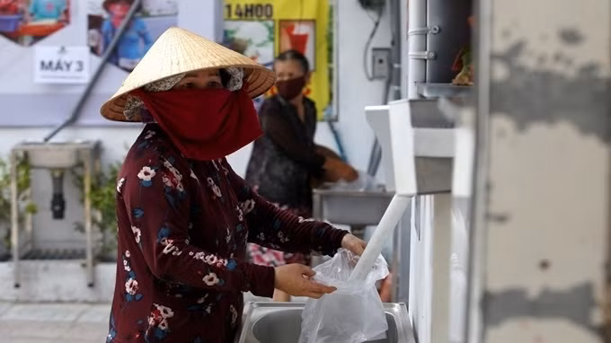 A woman receiving rice from a "rice ATM" in Ho Chi Minh City (Photo: Reuters)