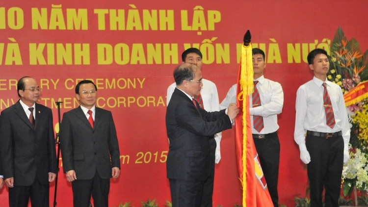 NA Chairman Nguyen Sinh Hung pins the Labour Order, first class, on SCIC's traditional flag (Photo: VGP)