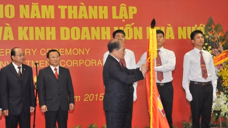 NA Chairman Nguyen Sinh Hung pins the Labour Order, first class, on SCIC's traditional flag (Photo: VGP)