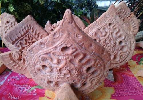 Roofing tiles in the shape of pipal leaves decorated with dragon patterns - a typical Tran dynasty architectural style.