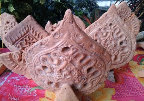 Roofing tiles in the shape of pipal leaves decorated with dragon patterns - a typical Tran dynasty architectural style.