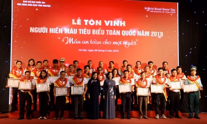 Politburo member Truong Thi Mai and Minister of Health Nguyen Thi Kim Tien presents certificates of merit to the outstanding blood donors.