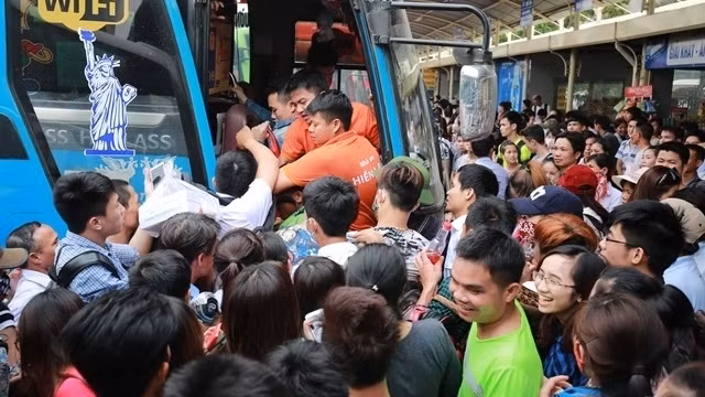 Passengers jostle to get on a bus at My Dinh Bus Station.