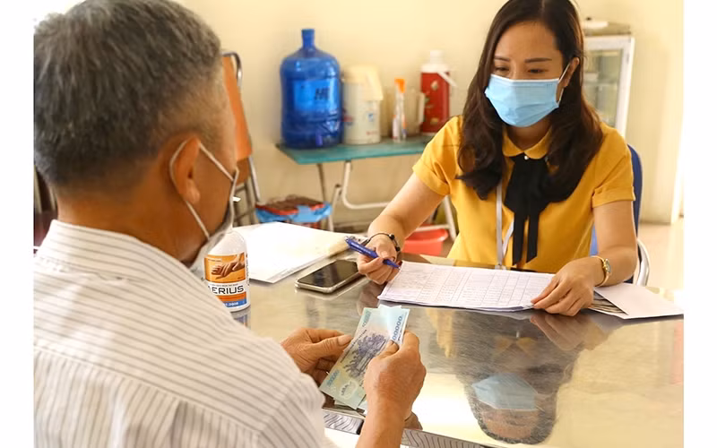 Financial support provided for people affected by COVID-19 under Resolution 68 in Thach Ban ward, Long Bien district, Hanoi (Photo: Hoang Hieu)