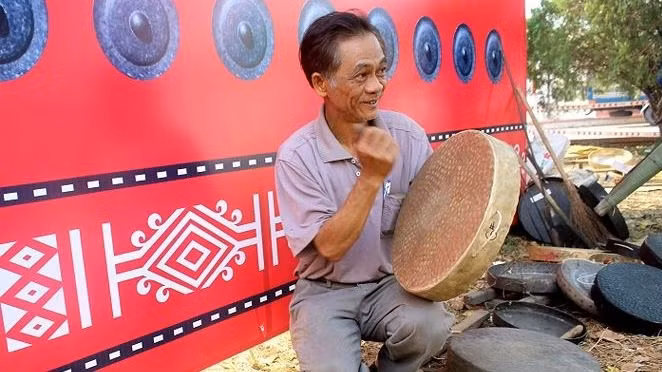 An artisan tests the sound of a gong at the event. (Photo: tienphong.vn)