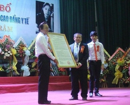 Deputy Minister of Education and Training Bui Van Ga (centre) grants the Ministry’s establishment decision to the college rector