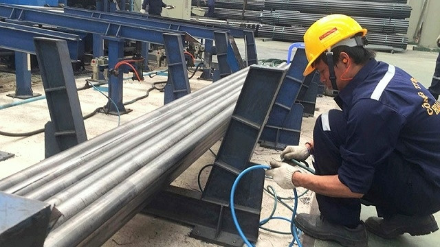 A worker at Hoa Sen hot-dip galvanised steel pipe plant during his working hours. (Photo: NDO/Quang Quy)