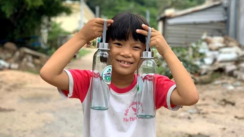 A kid in Cu Lao Xanh joyfully shows eco-friendly gifts received in exchange for plastic waste. (Photo: NDO/Ngoc Vy)