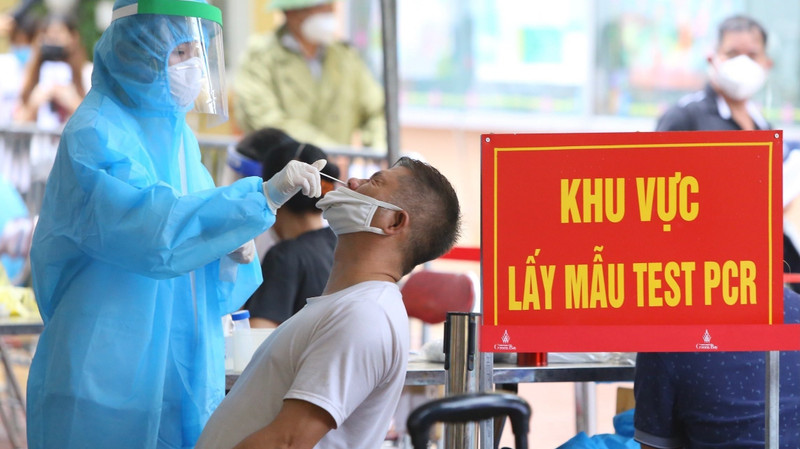 A medical worker collects the sample of a Hanoi resident to test for coronavirus. (Photo: VNA)