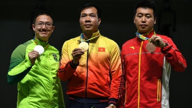 Vietnam's gold medallist Hoang Xuan Vinh (C) poses on the podium with Brazil's silver medal winner Felipe Almeida Wu (L) and China's bronze medallist Pang Wei (R).