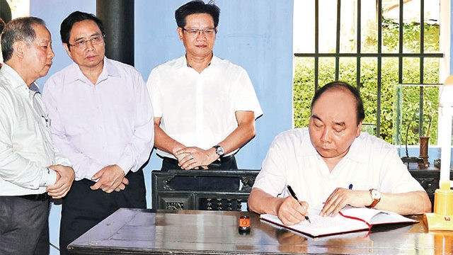PM Nguyen Xuan Phuc writes in a memorial book dedicated to President Ho Chi Minh at his memorial house in Hue city, Thua Thien - Hue province, September 1, 2019. (Photo: VNA)