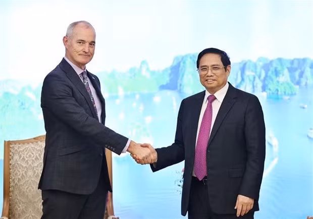 Prime Minister Pham Minh Chinh (R) shakes hands with President of the RMIT University Prof Alec Cameron (Photo: VNA)