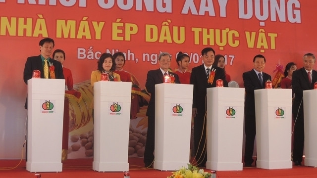 Delegates press the button to launch work on the factory.