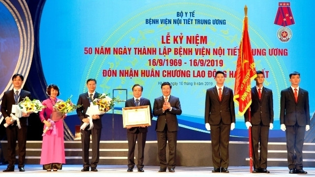 Deputy PM and FM Pham Binh Minh (fifth from left) presents the Labour Order, first class to the National Hospital of Endocrinology. (Photo: NDO/Minh Hoang)