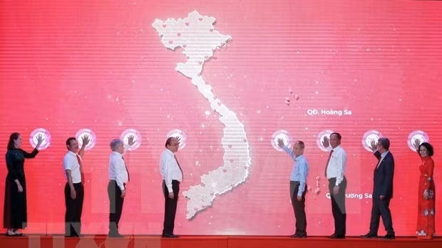 President Nguyen Xuan Phuc (fourth from left) and delegates launch the Humanitarian Month (Photo: VNA)