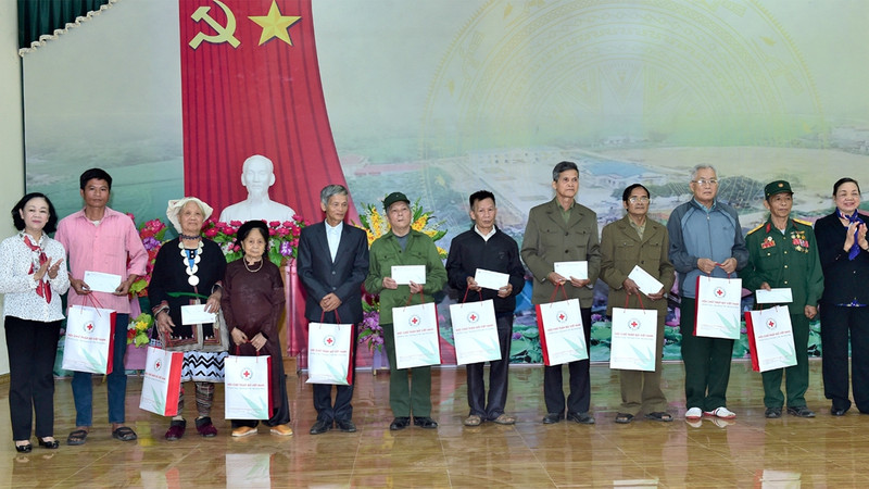 Head of the PCC’s Organisation Commission Truong Thi Mai (leftmost) presents gifts to people with meritorious services to the revolution along with ethnic minorities in difficult circumstances in Xuan Quang Commune, Chiem Hoa District.