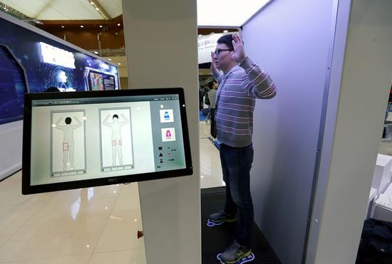 An exhibitor demonstrates a security scanner that uses millimeter wave imaging at a science and technology convention in Xi'an, Shaanxi province, last year. The technology was introduced recently for use in civil aviation in China. (Photo: China News Service/Zhang Yuan)