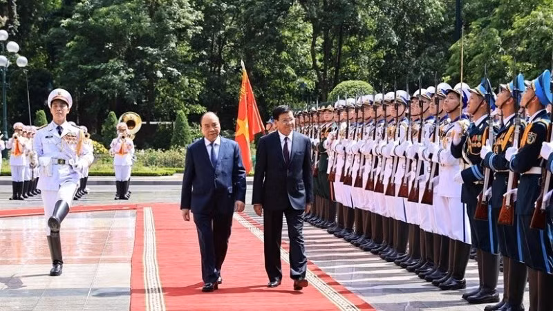 Vietnamese President Nguyen Xuan Phuc (L) and General Secretary of the Lao People’s Revolutionary Party Central Committee and President of Laos Thongloun Sisoulith inspect the guard of honour at the welcome ceremony in Hanoi on June 28 (Photo: VNA)