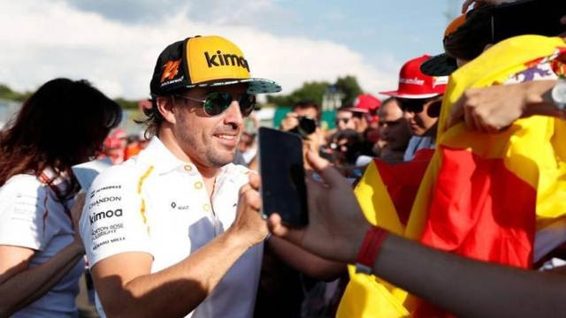 McLaren's Fernando Alonso signs his autograph for fans ahead of the Hungarian Grand Prix. (Photo: Reuters)