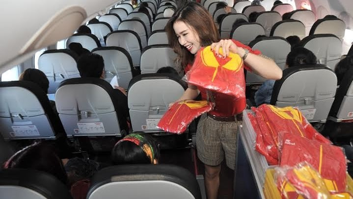 A flight attendant presenting gifts to passengers on the opening day