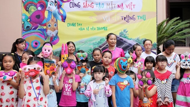 Lecturer Trang Thanh Hien (in pink, centre) and children wearing their hand-made masks at the event held at the Vietnam Fine Arts Museum on September 13 (Photo: VN+)