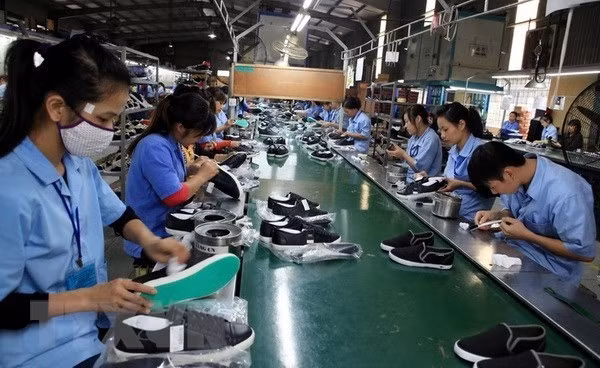 Producing footwear for export (Photo: VNA)