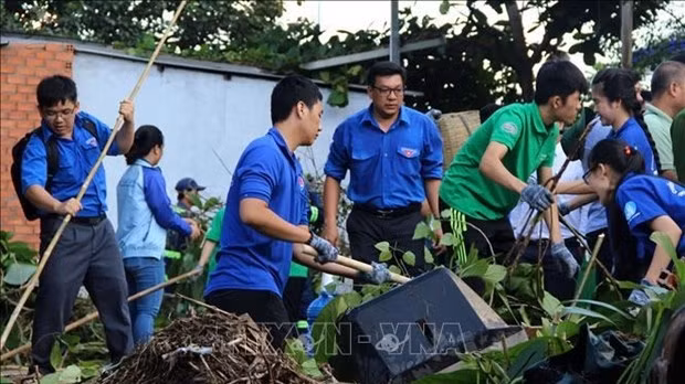 Young people take part in an environmental cleanup programme. (Photo: VNA)