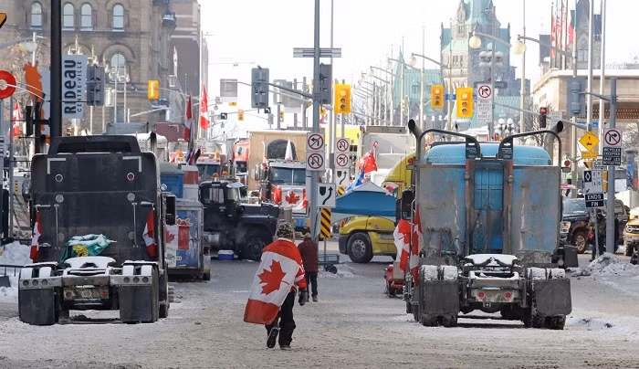 A person walks by trucks blocking roads downtown as truckers and their supporters continue to protest coronavirus disease (COVID-19) vaccine mandates, in Ottawa, Ontario, Canada, February 7, 2022. (Photo: Reuters)