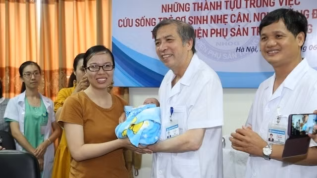 Director of the National Hospital of Obstetrics and Gynecology Vu Ba Quyen (C) congratulates the baby on hospital discharge on June 7. (Photo: NDO)
