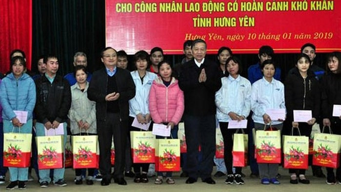 Minister of Public Security To Lam (seventh from left) presents Tet gifts to poor workers in Van Giang district, Hung Yen province (Photo: anninhthudo.vn)