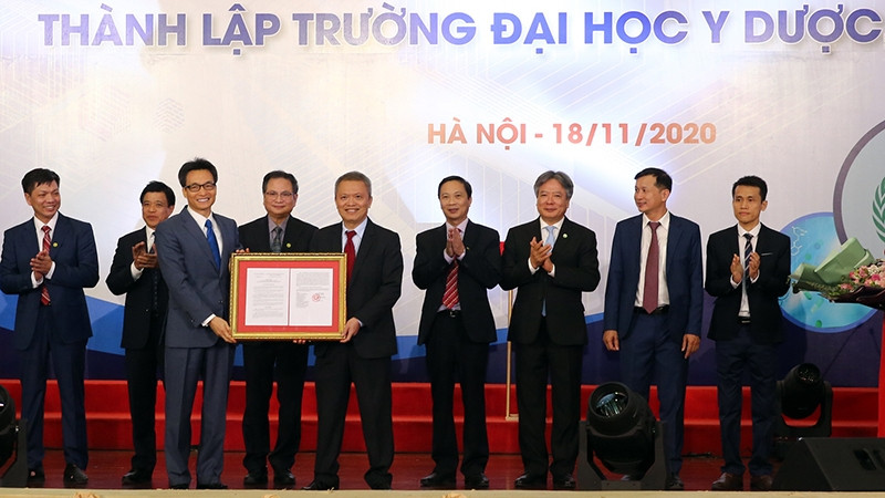 Deputy PM Vu Duc Dam presents the Prime Minister's decision to the university leaders.