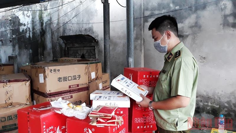Market managers check the quality of imported confectionery products. (Photo: Nguyen Trang)