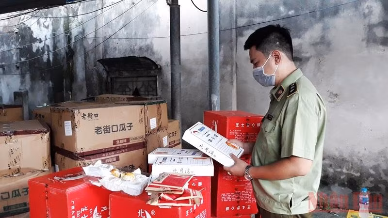 Market managers check the quality of imported confectionery products. (Photo: Nguyen Trang)