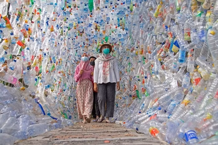 People walk through "Terowongan 4444" or 4444 tunnel, built from plastic bottles collected from several rivers around the city in three years, at the plastic museum constructed by Indonesia's environmental activist group Ecological Observation and Wetlands Conservation (ECOTON) in Gresik regency near Surabaya, East Java province, Indonesia, September 28, 2021. (Photo: Reuters)