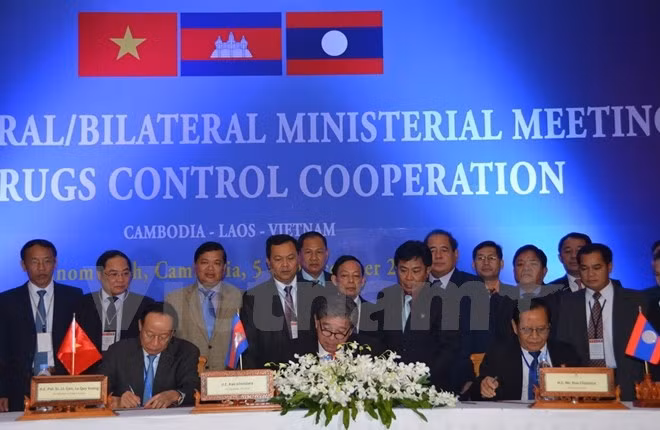 Heads of the three delegations sign the minutes of the meeting. (Photo: VNA)