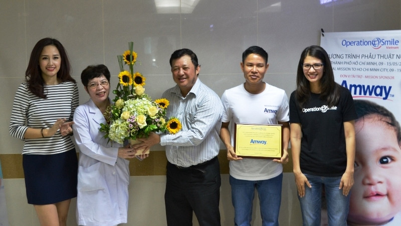 Representatives of Amway Vietnam and the HCMC Medical and Pharmaceutical University Hospital receive flowers from Operation Smile.