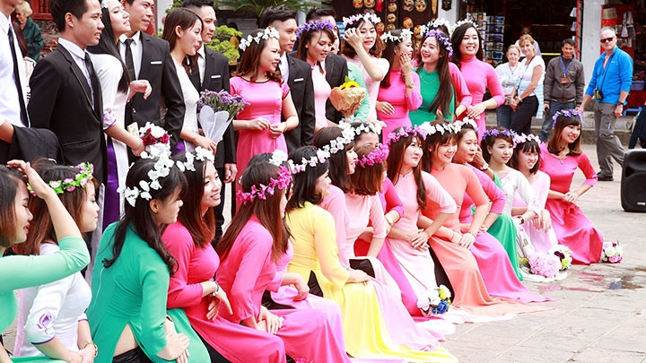 Female students wearing Ao Dai during their graduation ceremony.
