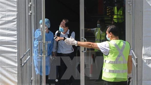 A passenger from Johor, Malaysia, via the land Vaccinated Travel Lane (VTL) leaves after getting negative test results for the antigen rapid test (ART) at Singapore's Queen Street bus terminal in November 2021. (Photo:Xinhua/VNA)