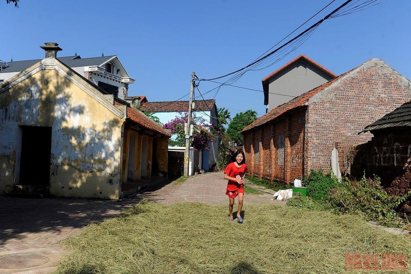 A girl playing on a road filled with straw 