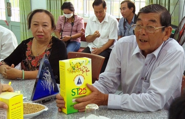 Labour Hero Ho Quang Cua (R) and his research team introduce their ST25 fragrant rice. (Photo: NDO/Nguyen Phong)