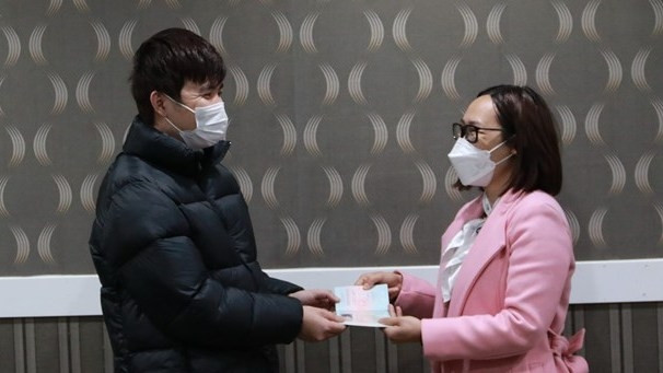 Ta Thi Thanh Thuy, head of the Vietnamese labour management board in the Republic of Korea, presents a new passport to a sailor at the meeting. (Photo: VNA)