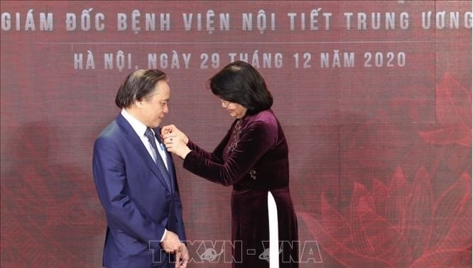 VP Dang Thi Ngoc Thinh presents the “Labour Hero in Renewal Period” title to Associate Professor, People’s Doctor Tran Ngoc Luong. (Photo: VNA)