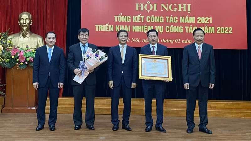 Head of the Central Economic Commission Tran Tuan Anh presents a certificate of merit to the bloc's Party Committee.