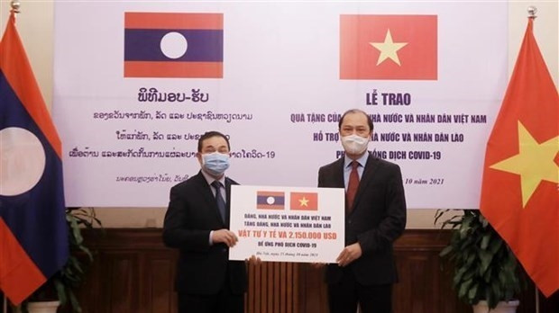 Deputy Minister of Foreign Affairs Nguyen Quoc Dung (R) presents a token of the gifts to at the event Lao Ambassador to Vietnam Sengphet Houngboungnuang (Photo: VNA)