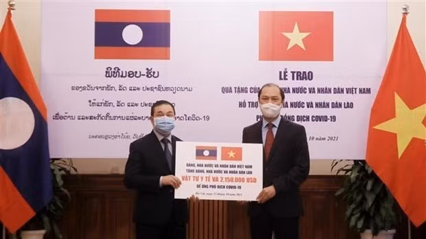 Deputy Minister of Foreign Affairs Nguyen Quoc Dung (R) presents a token of the gifts to at the event Lao Ambassador to Vietnam Sengphet Houngboungnuang (Photo: VNA)