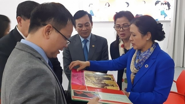 The delegates reading the photo book "Ho Chi Minh, a person and a nation" (Photo: thoidai.com.vn)