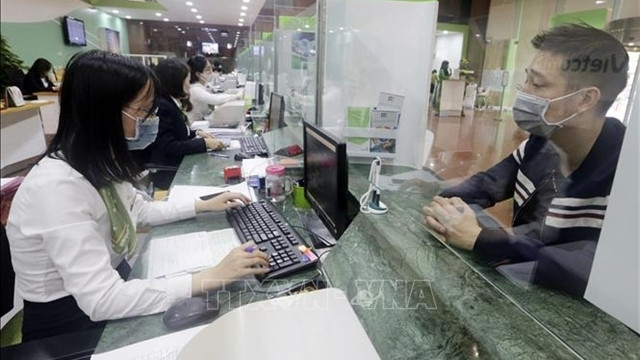 Sixteen commercial banks have voluntarily agreed to cut interest rates of about VND20.3 trillion from now until the end of this year. (Photo: VNA)