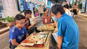 Residents try out traditional folk games at the festival. (Photo: VNA)