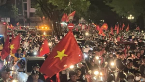 People take to Hanoi streets waving the national flag in celebration of the victory. (Photo: VNA)