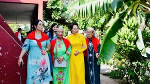 NA Chairman Tran Thanh Man's spouse, Nguyen Thi Thanh Nga and delegates visit a local household in the Vietnamese Village. (Photo: nhandan.vn)